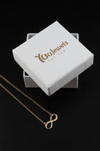 Gold infinity pendant necklace with fine chain on white gift box