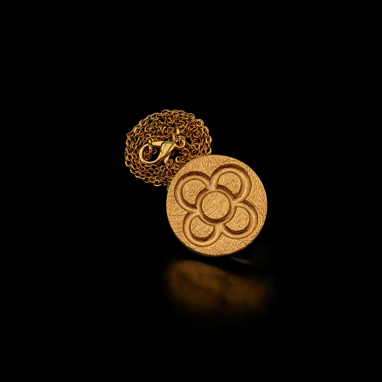 Gold round flower pendant necklace on chain, circular embossed flower motif