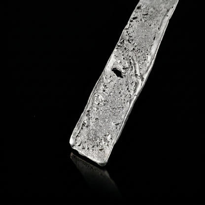 Silver strata necklace pendant close-up with textured silver slab