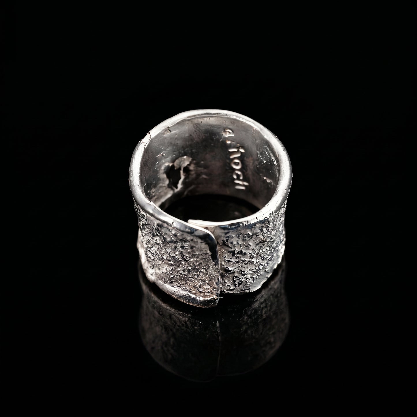 Silver strata ring interior view with stamped markings and textured exterior