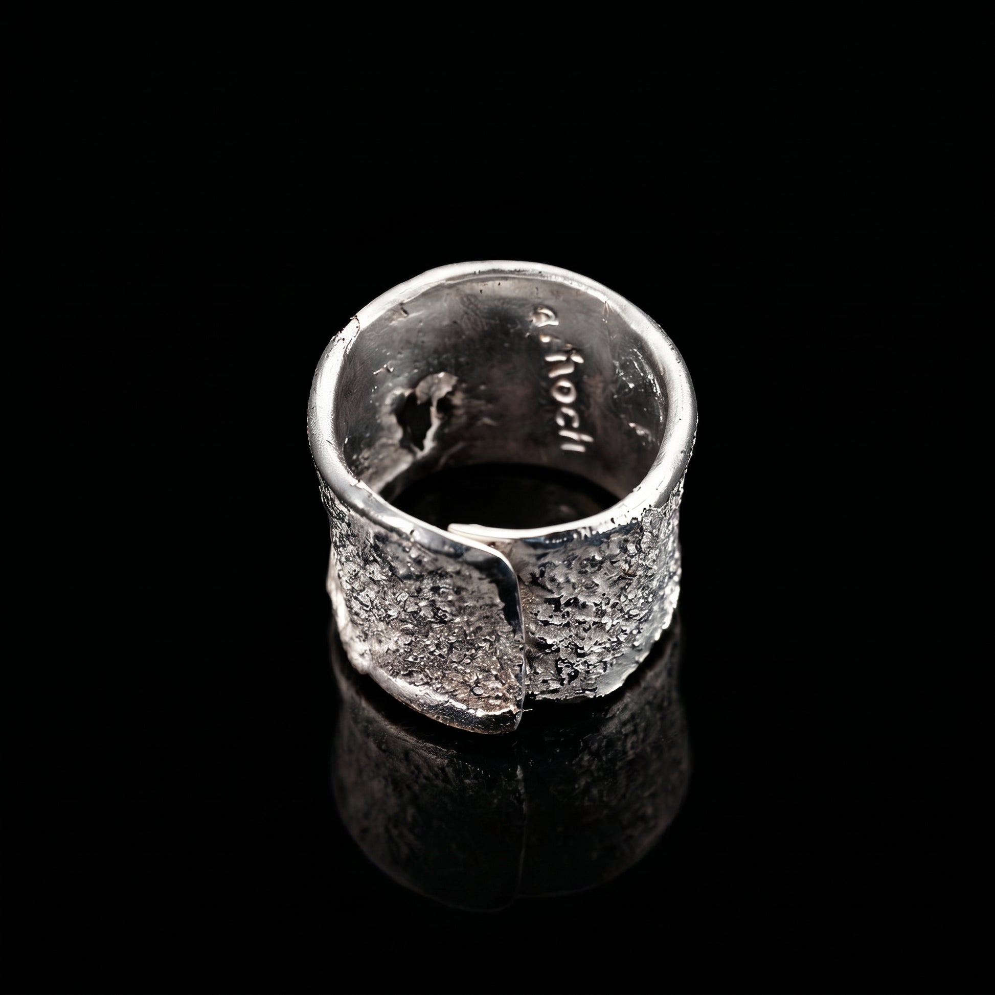 Silver strata ring interior view with stamped markings and textured exterior