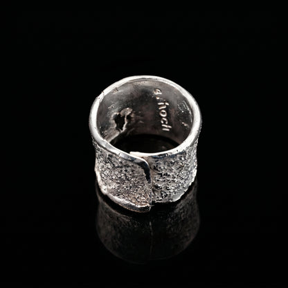 Silver strata ring interior view with stamped markings and textured exterior