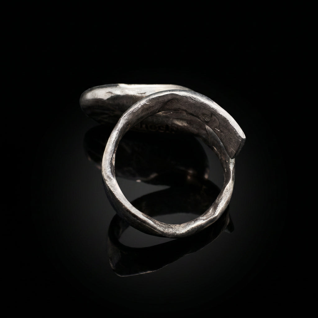 Anillo ovalado abierto en tono plateado con silueta curva