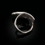 Anillo ovalado abierto en tono plateado con silueta curva
