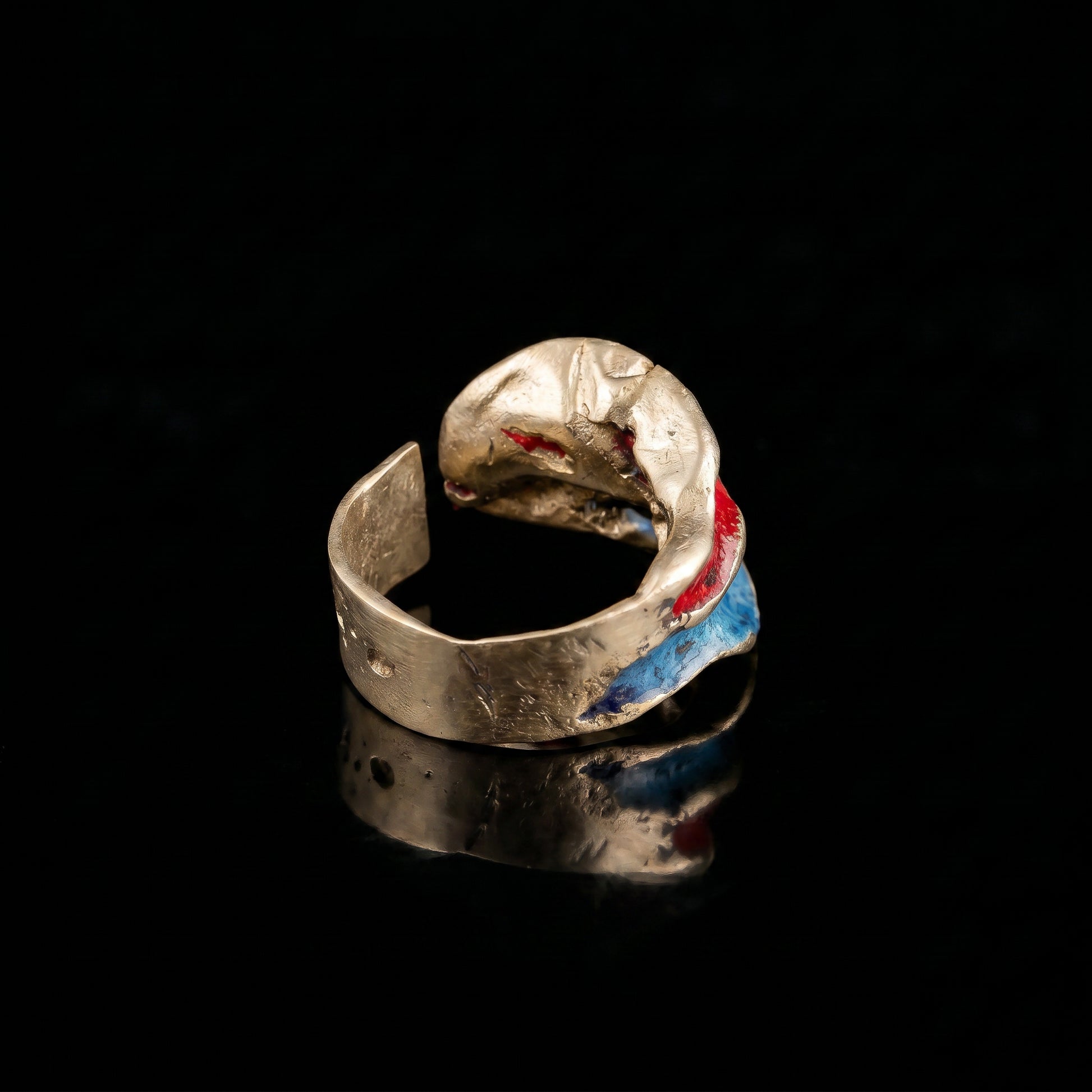 Gold-tone open ring with blue and red resin accents on hammered band