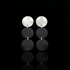 Arracades de tres discs amb part superior platejada i dues penjolls de disc gris fosc apilats
