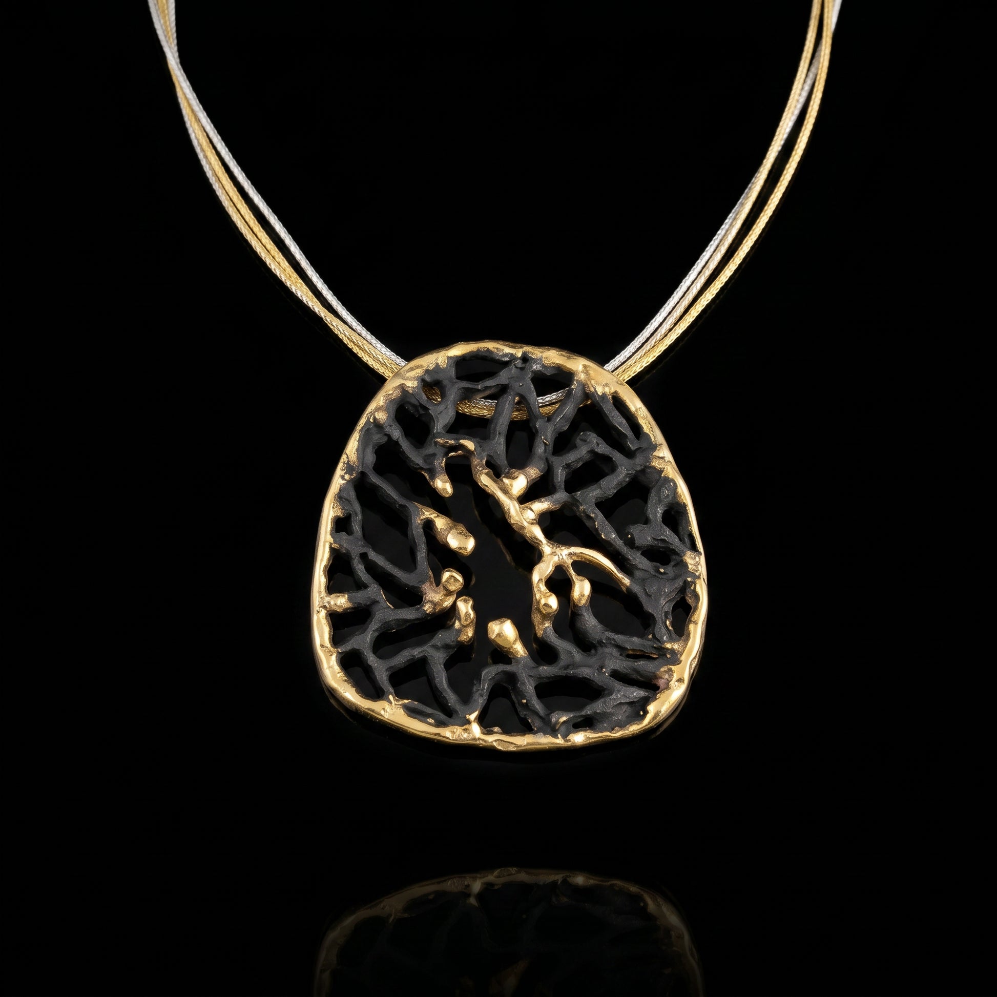 Orbis pendant with dark round filigree and gold-toned rim on thin chain