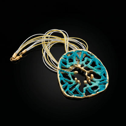Orbis pendant with turquoise round filigree cutout and gold-toned rim on chain