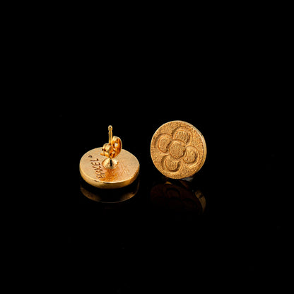 Gold round stud earrings with raised flower pattern, side view with post