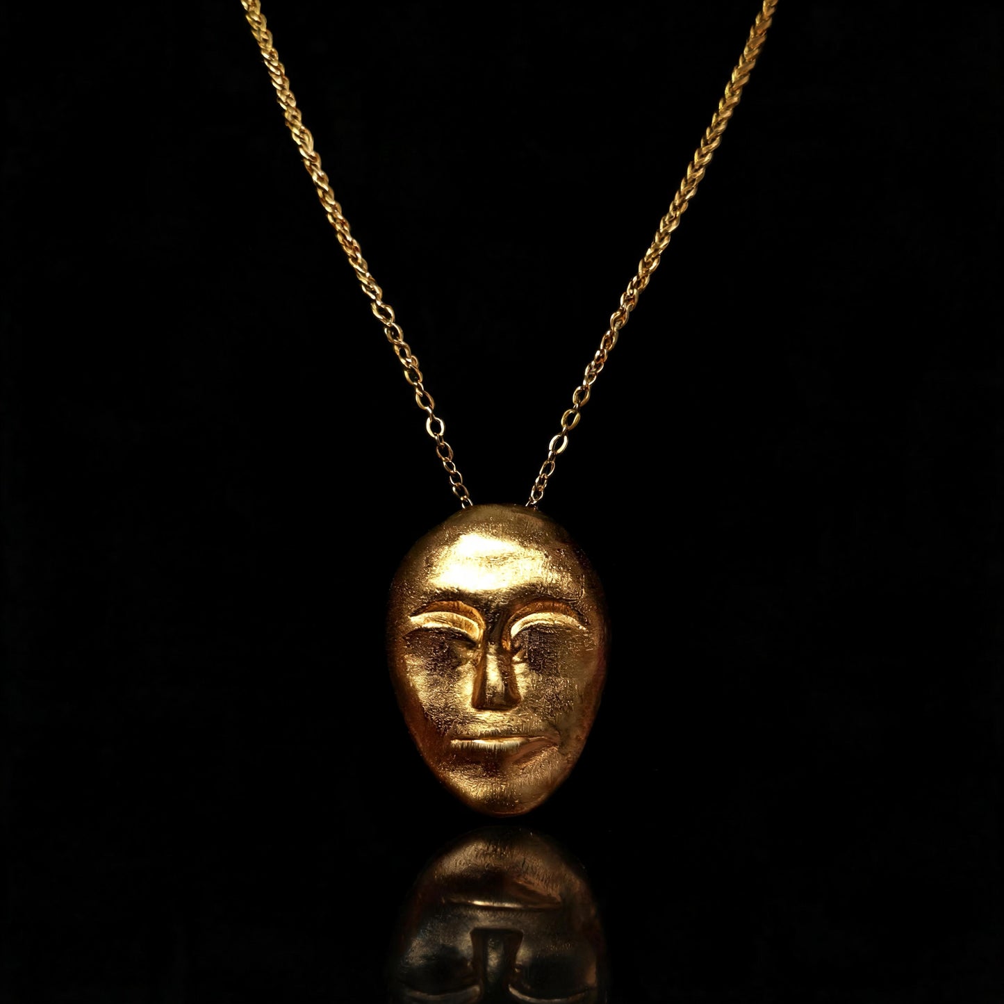 Gold face-mask pendant necklace with a fine chain link