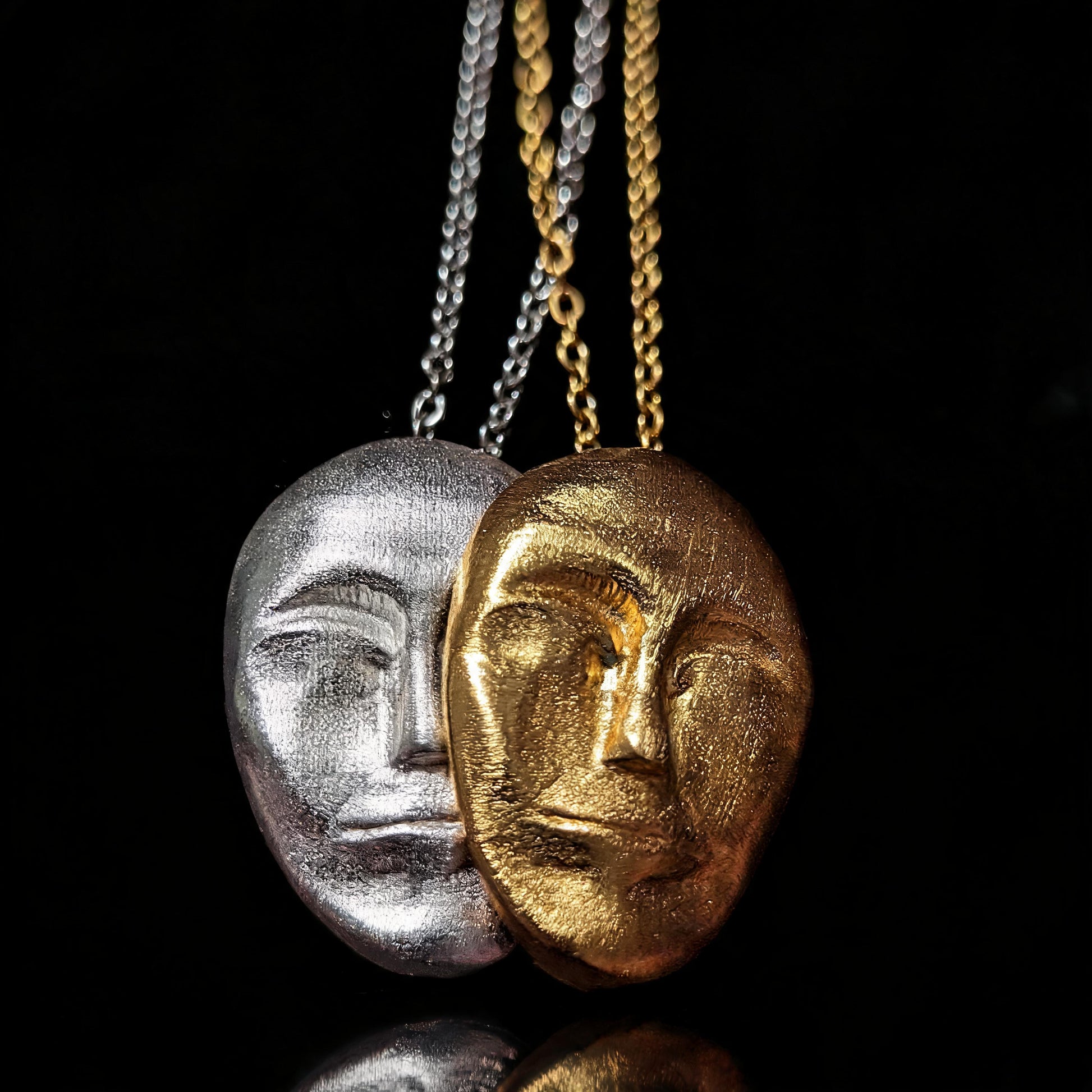 Double pendant necklace with silver and gold face masks on two chain strands
