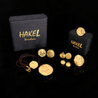 Conjunto de pendientes de botón y colgantes de oro con pequeños discos redondos, mostrados con cajas HAKEL