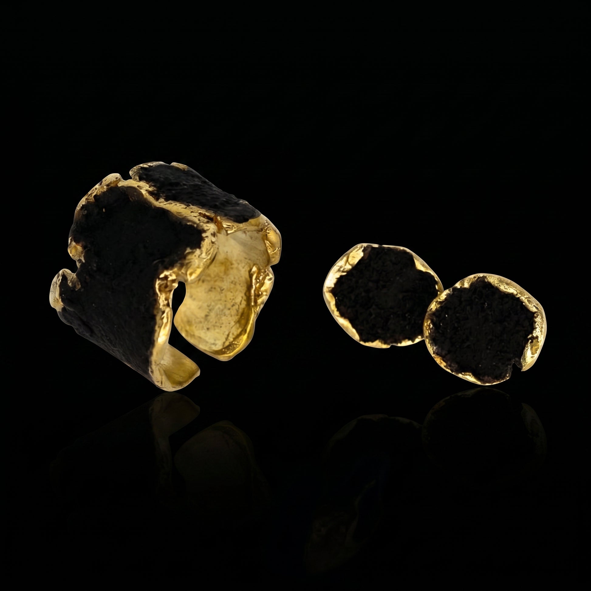 Gold-tone ring with dark stone and two small disc details