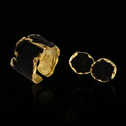 Gold-tone ring with dark stone and two small disc details