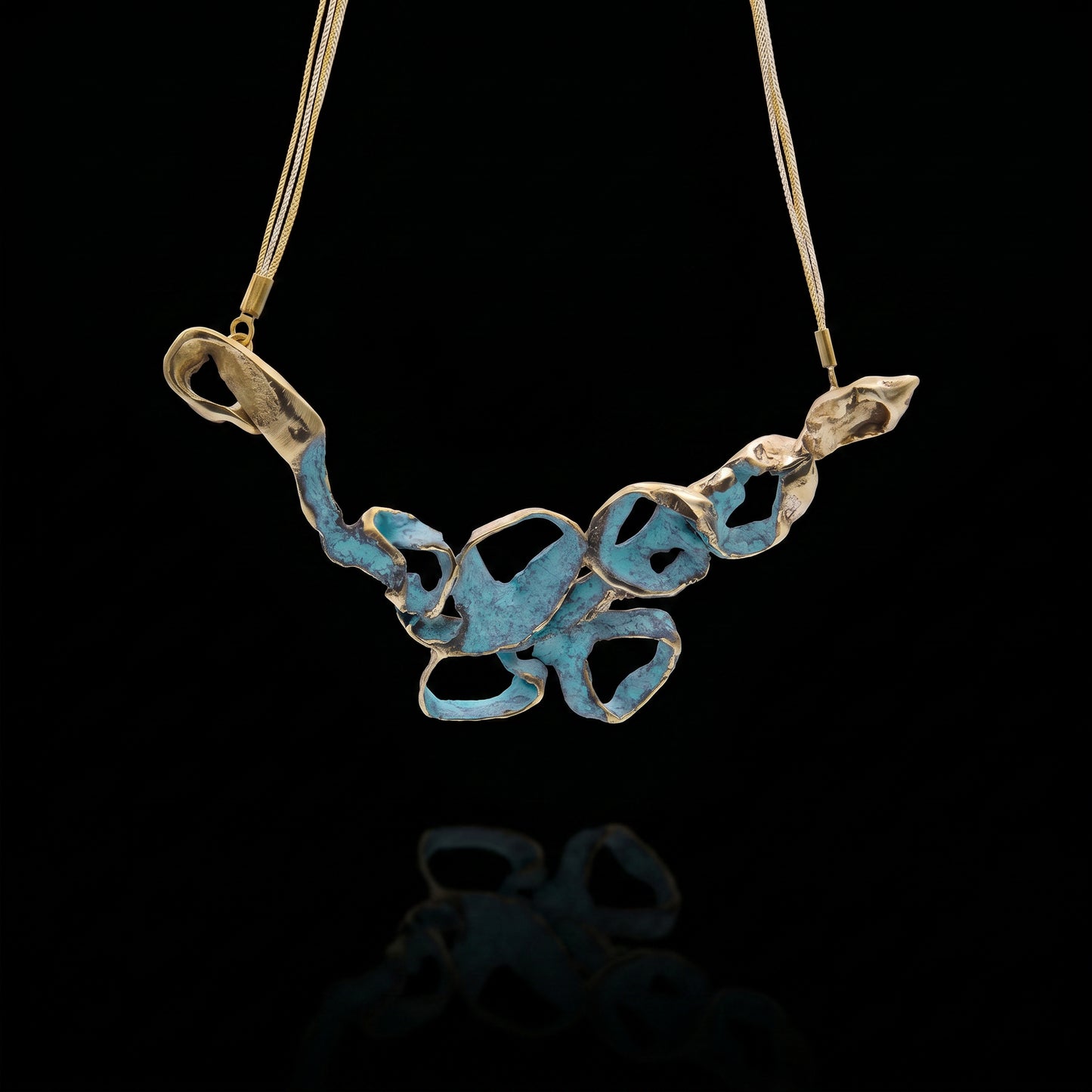 Turquoise coral-style pendant necklace with openwork metal charms on a gold-tone chain