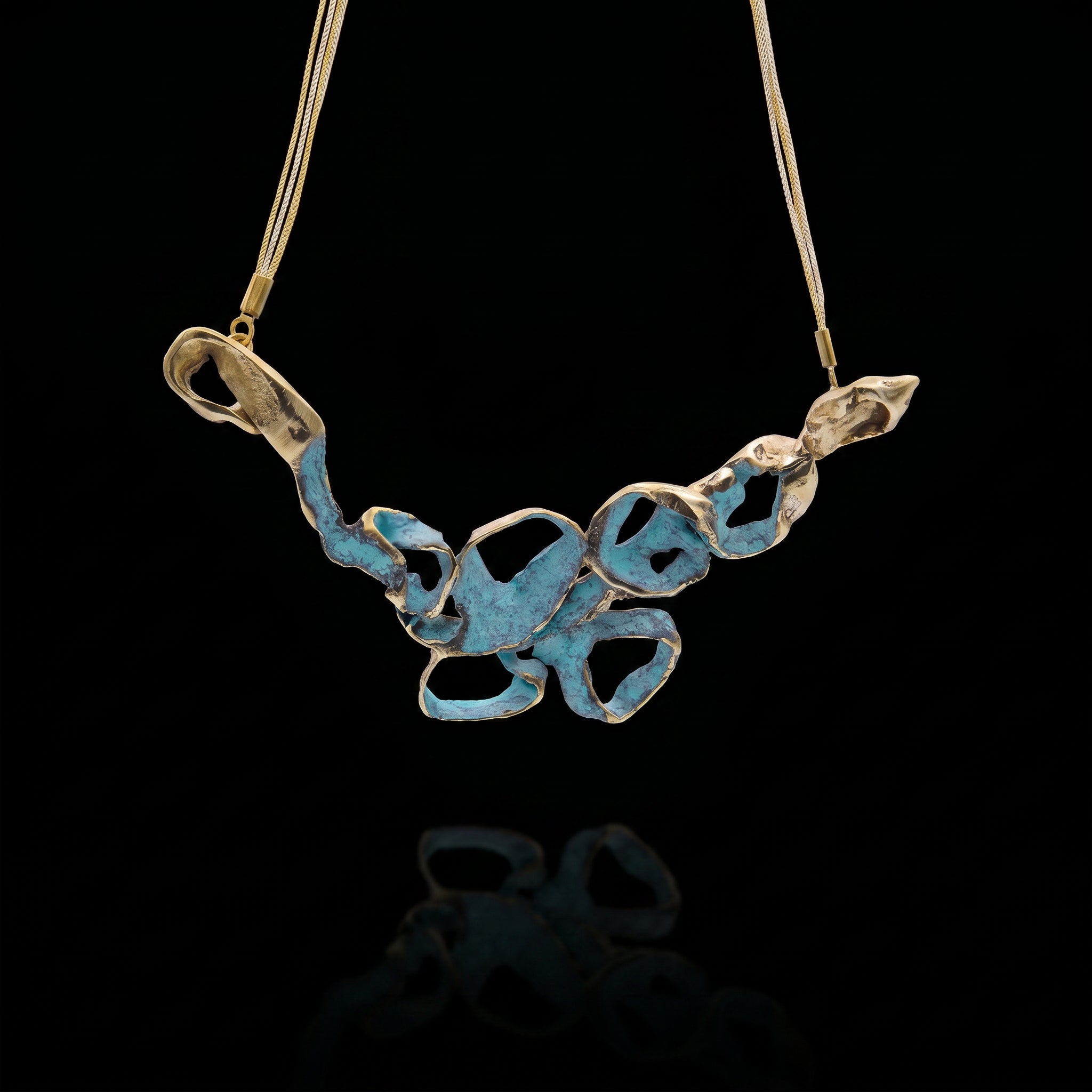 Turquoise coral-style pendant necklace with openwork metal charms on a gold-tone chain
