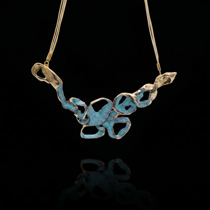 Turquoise coral-style pendant necklace with openwork metal charms on a gold-tone chain