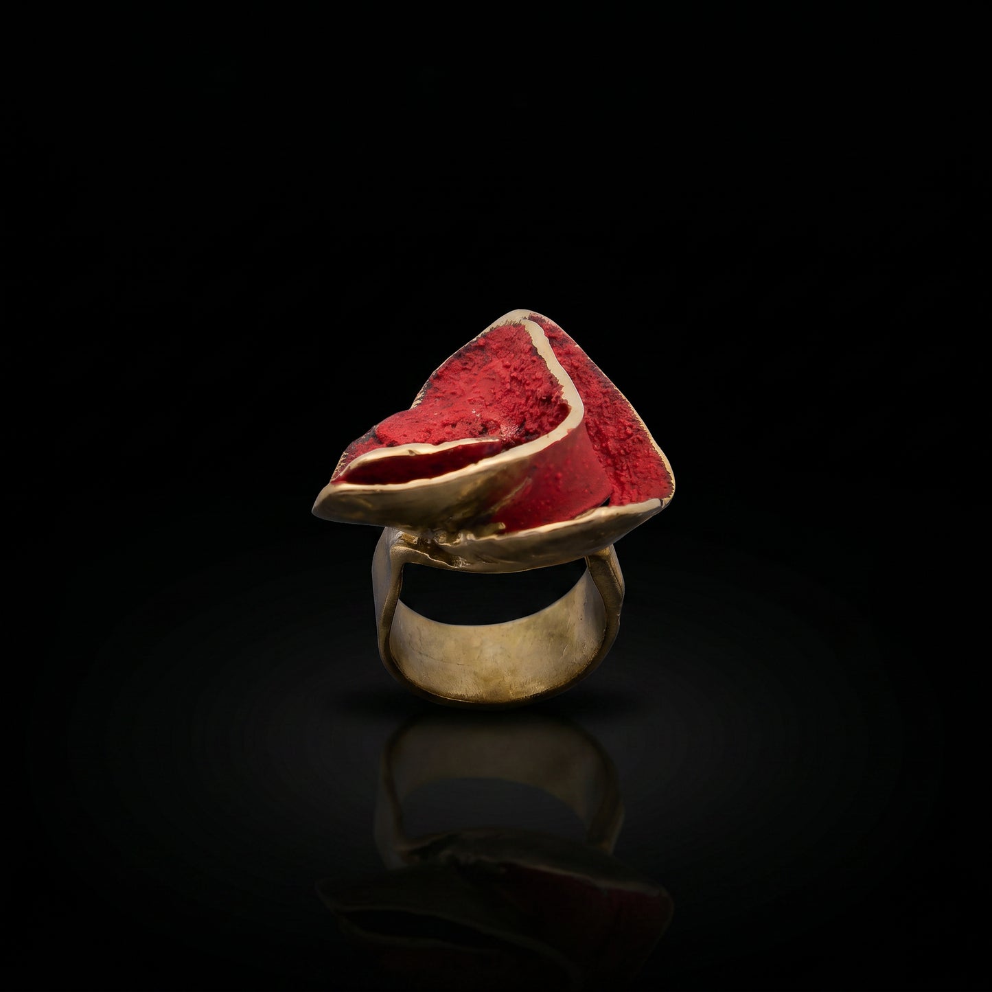 Rosella ring with gold-tone band and red triangular gemstone top with pale edging