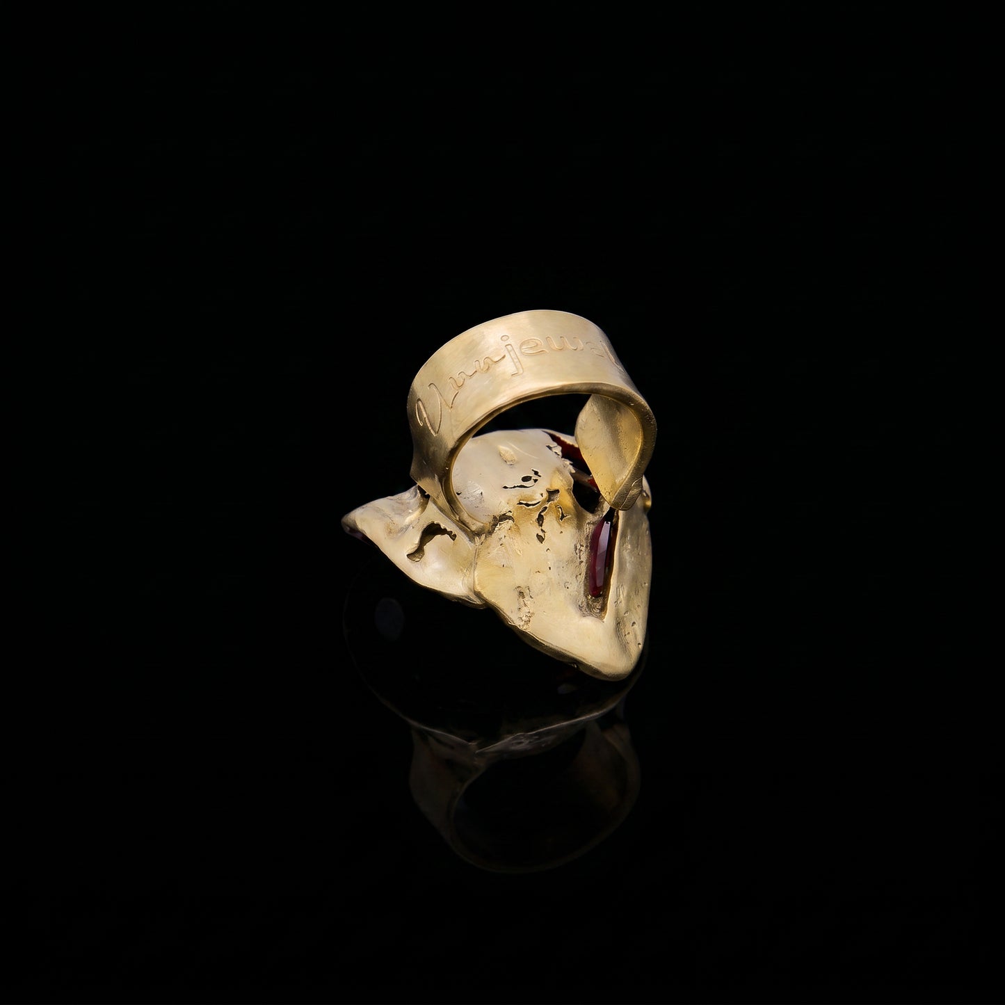 Gold-tone face-shaped ring with red inner detail and open front
