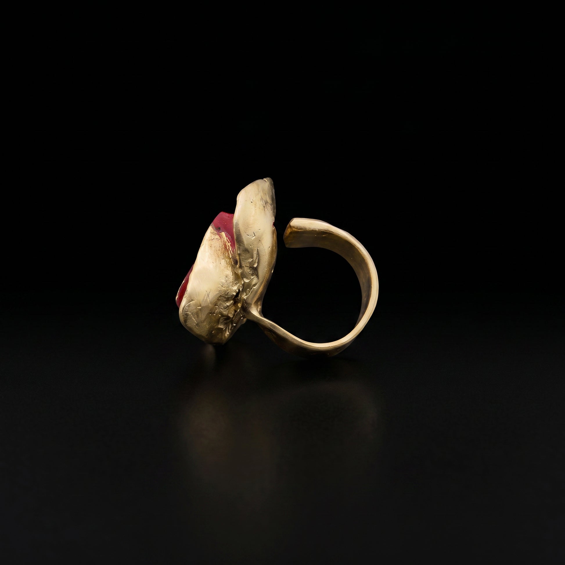 Gold-tone ring with red stone top and open side setting