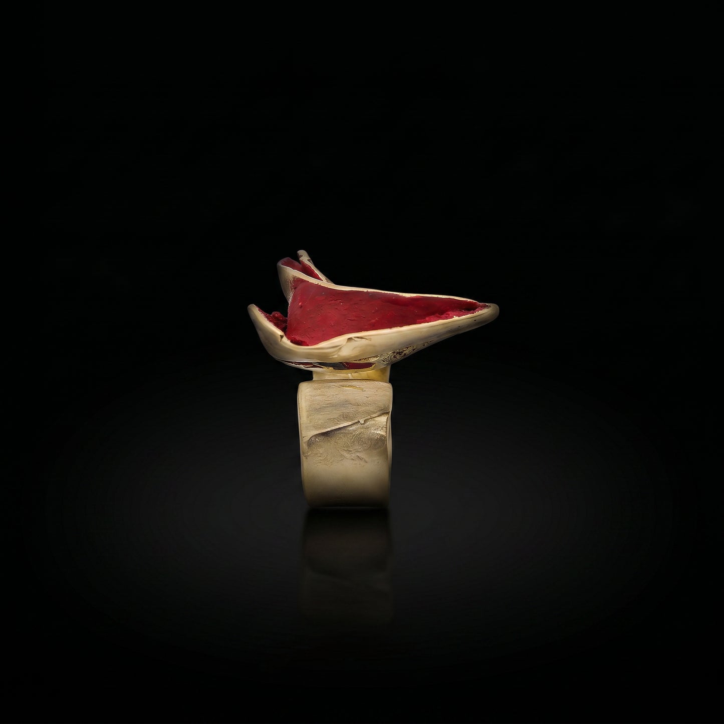 Gold-tone ring with red oval gemstone top and wide open band