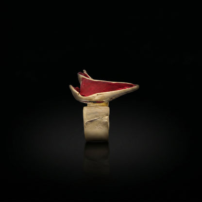 Gold-tone ring with red oval gemstone top and wide open band