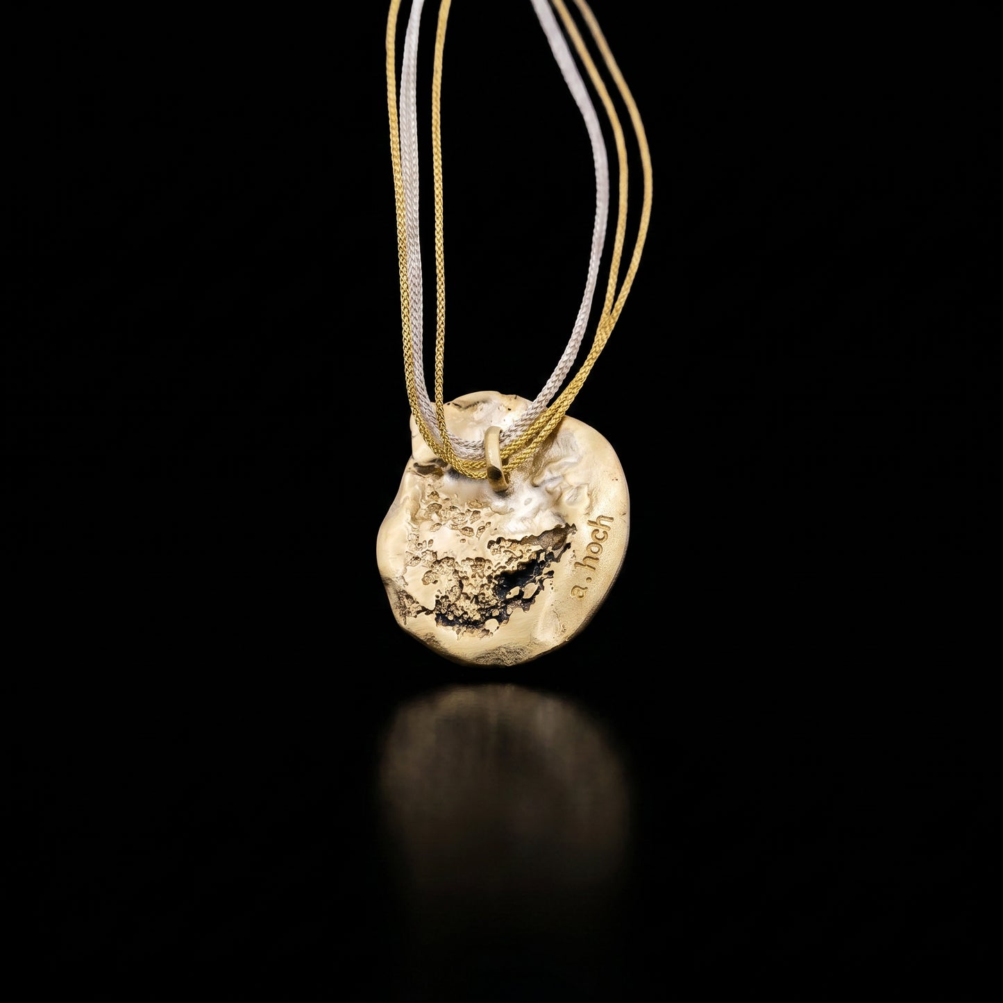 Gold-toned heart-shaped pendant necklace with multiple thin cords