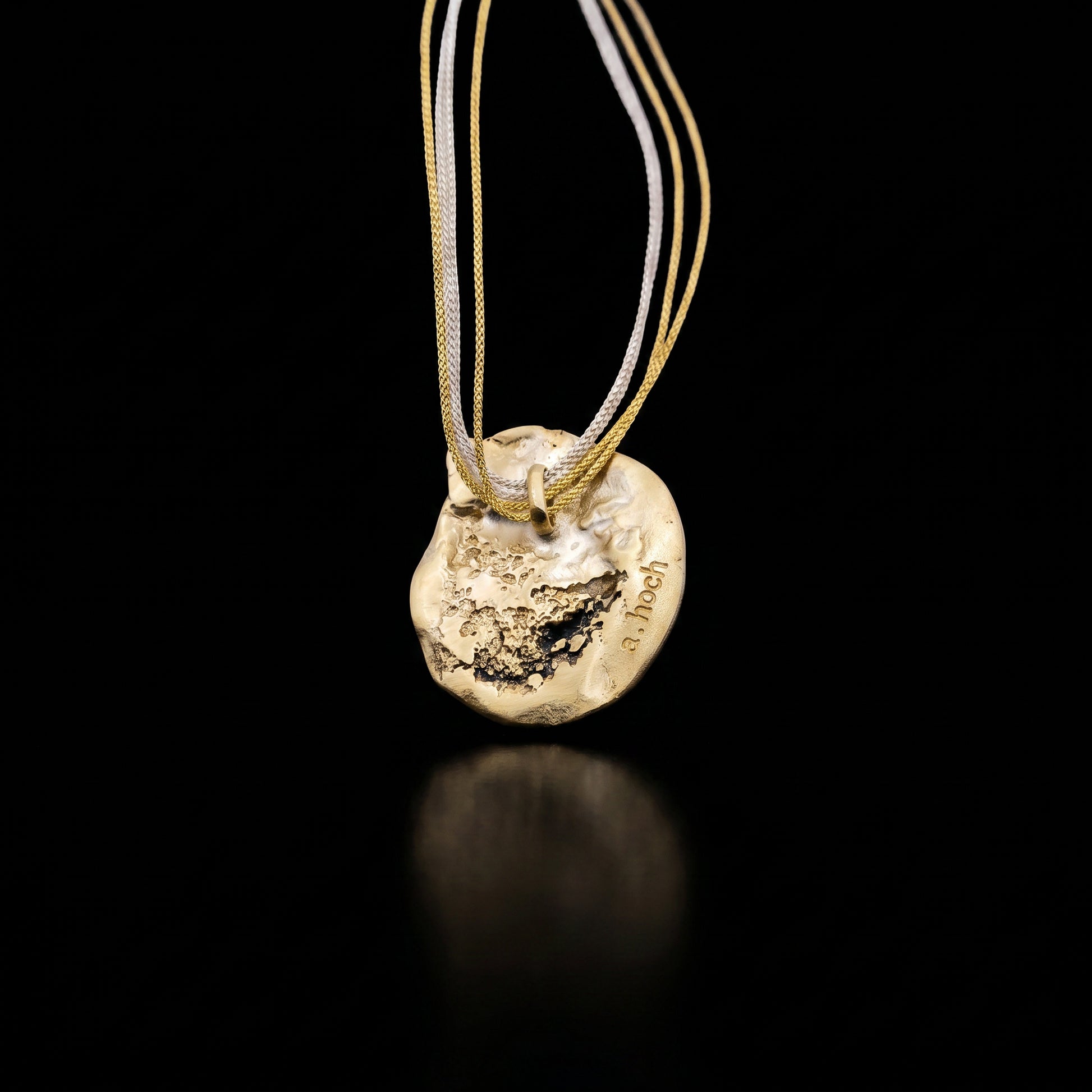 Gold-toned heart-shaped pendant necklace with multiple thin cords