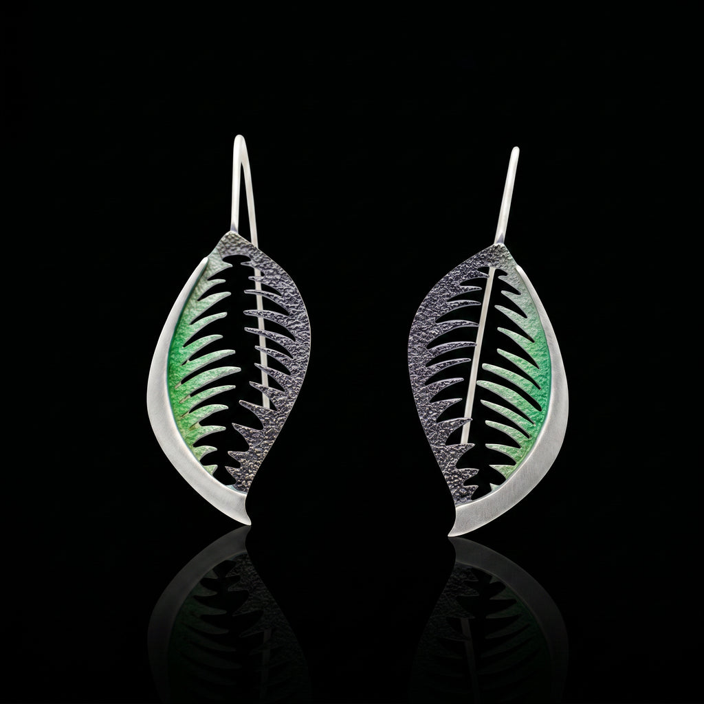 Veined leaf earrings with green veining on black, silver-tone wire hooks.
