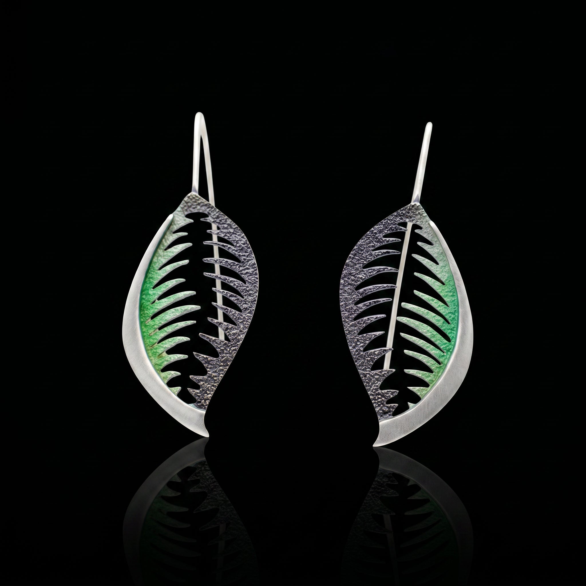 Veined leaf earrings with green veining on black, silver-tone wire hooks.