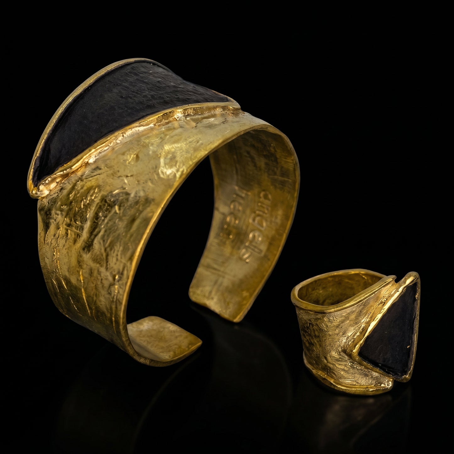 Gold tone triangle-stone ring with dark triangular inset, plus matching small ring