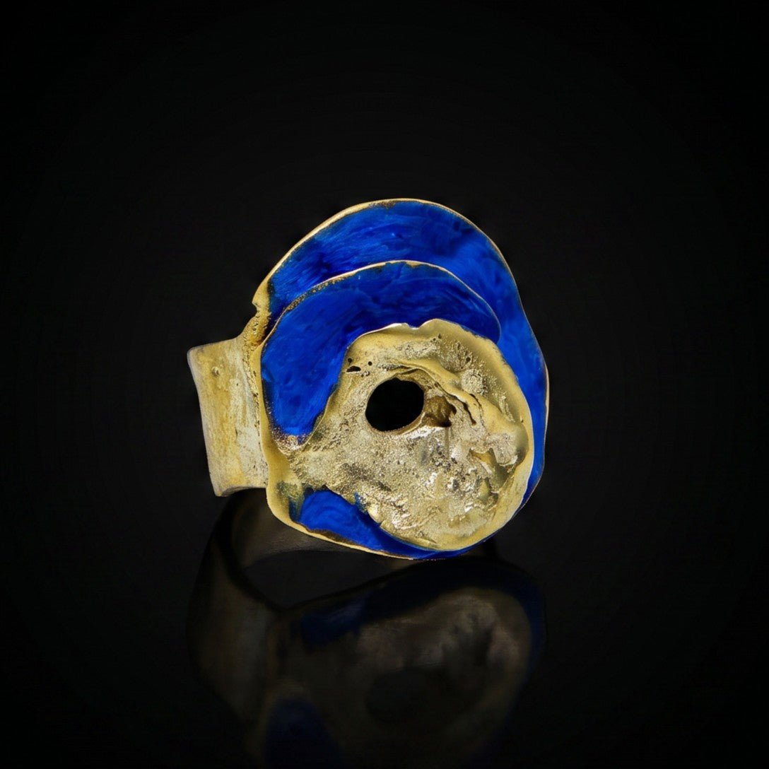 Gold ring with blue oval top and dark circular center setting