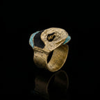 Gold-tone ring with turquoise and dark-blue inlay oval top and dark center hole