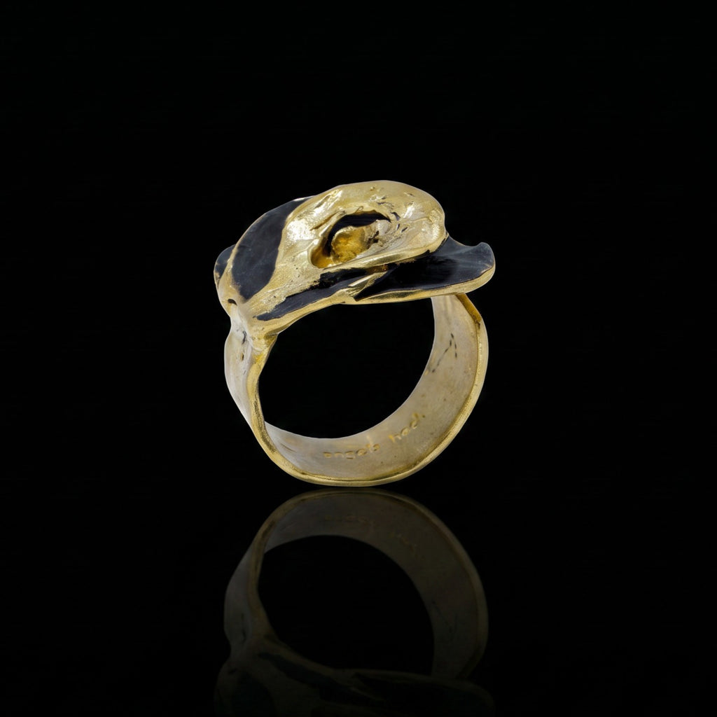 Gold-tone statement ring with raised oval bezel and dark center setting