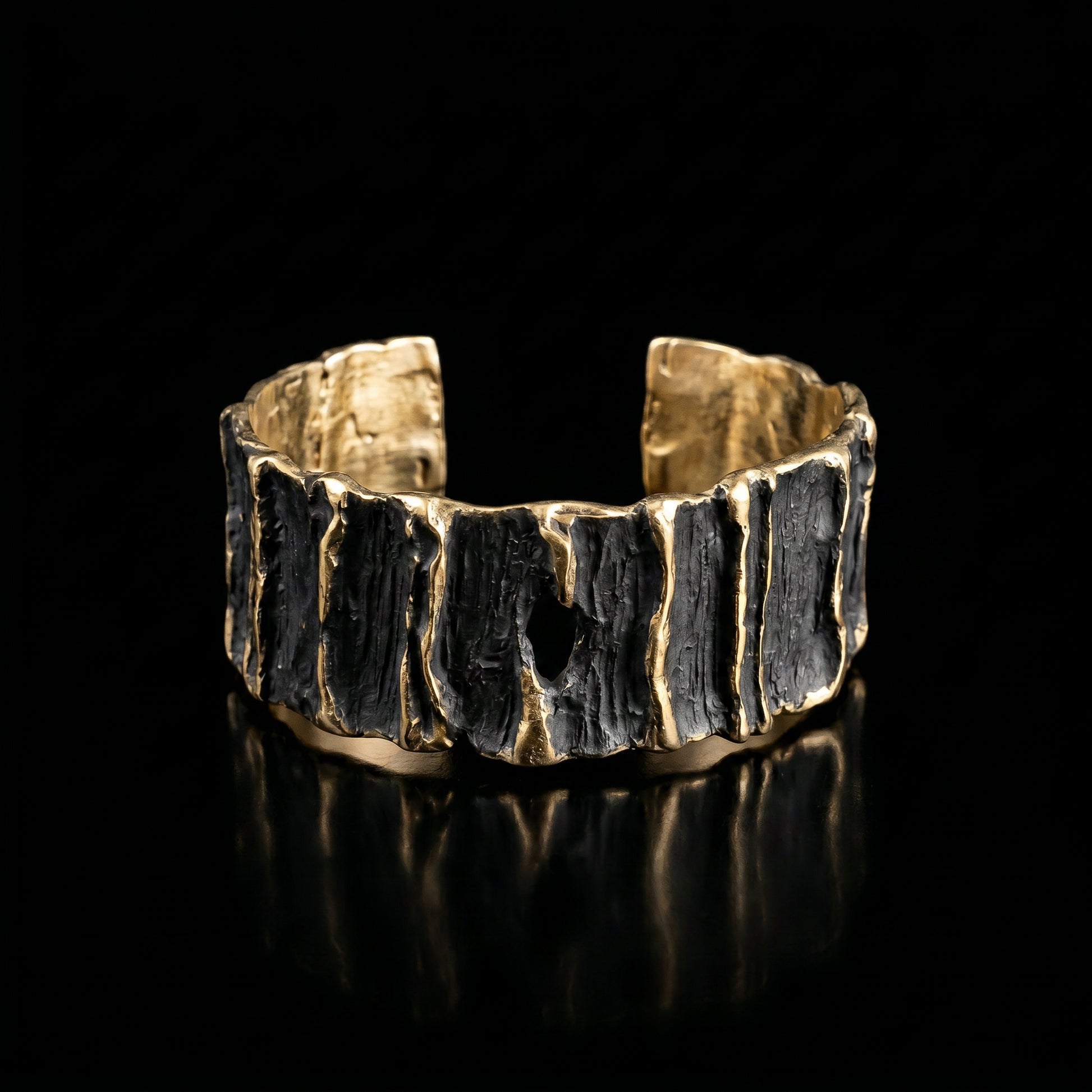 Sculpted wide cuff bracelet with dark ridged center and gold-tone top and bottom