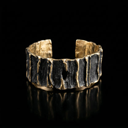 Sculpted wide cuff bracelet with dark ridged center and gold-tone top and bottom