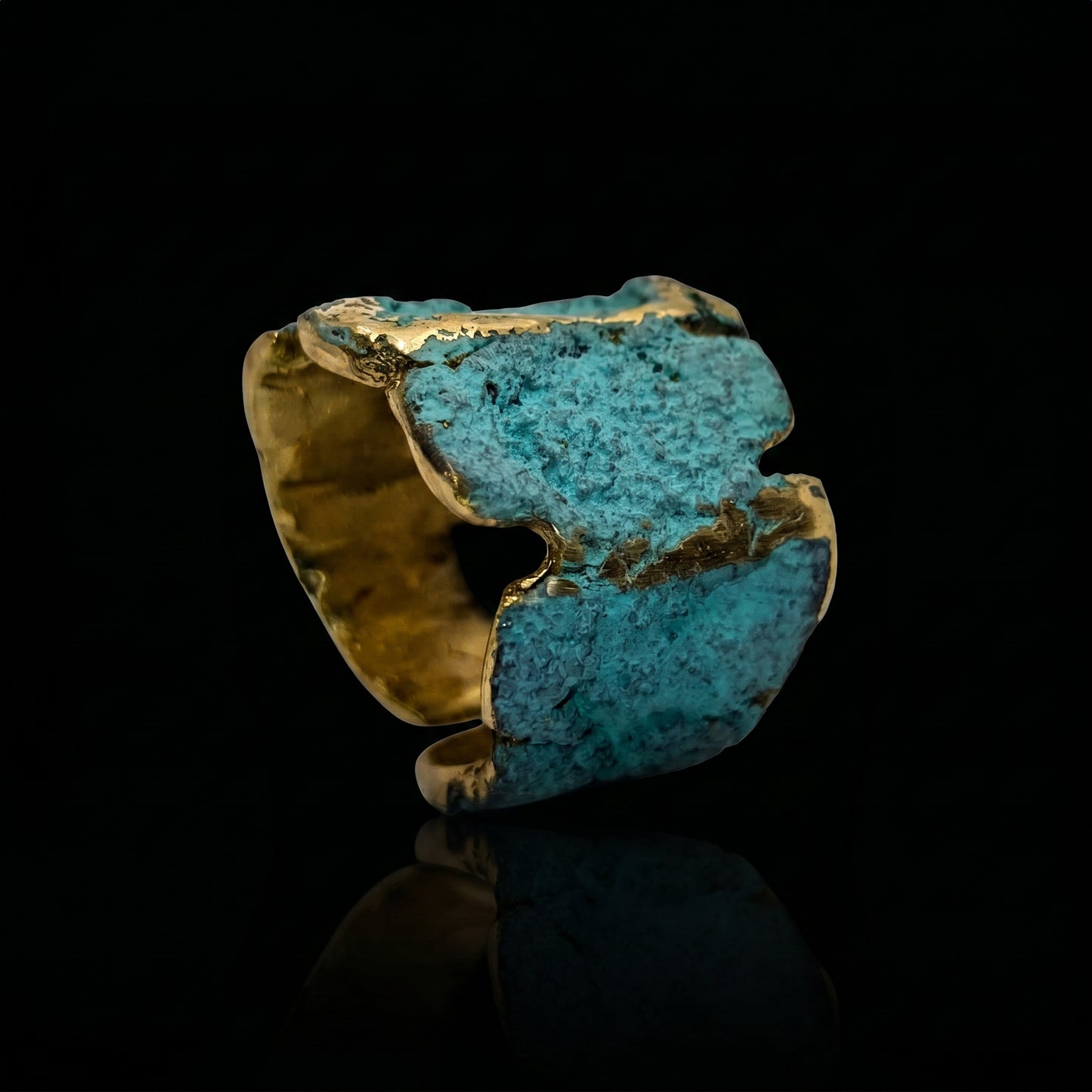 Gold-tone cuff ring with turquoise-blue center and jagged edges