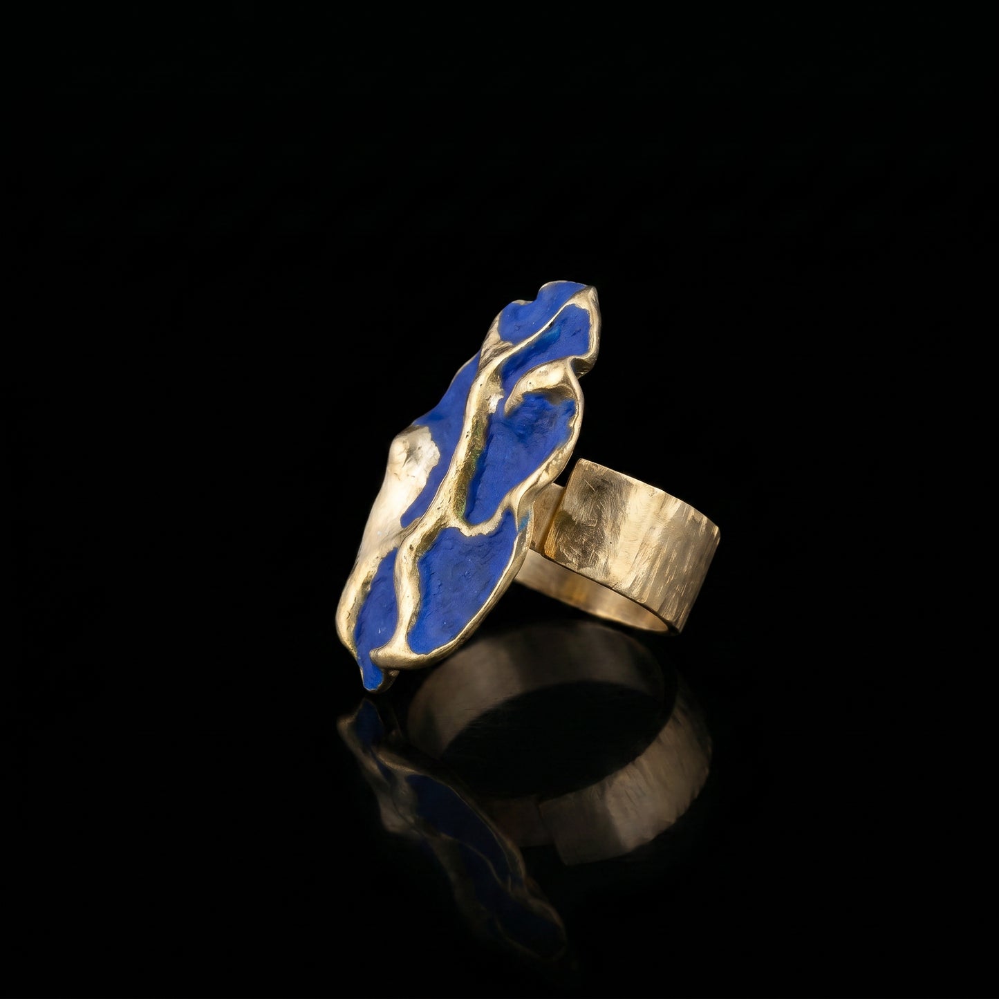 Blue enamel concept ring with gold-tone band, angled side view