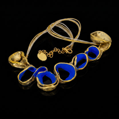 Gold-tone necklace with blue oval link beads and shell-shaped pendants