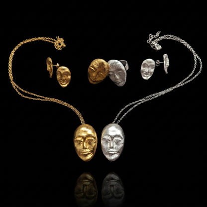 Gold and silver oval face rings with sculpted facial designs and wide bands