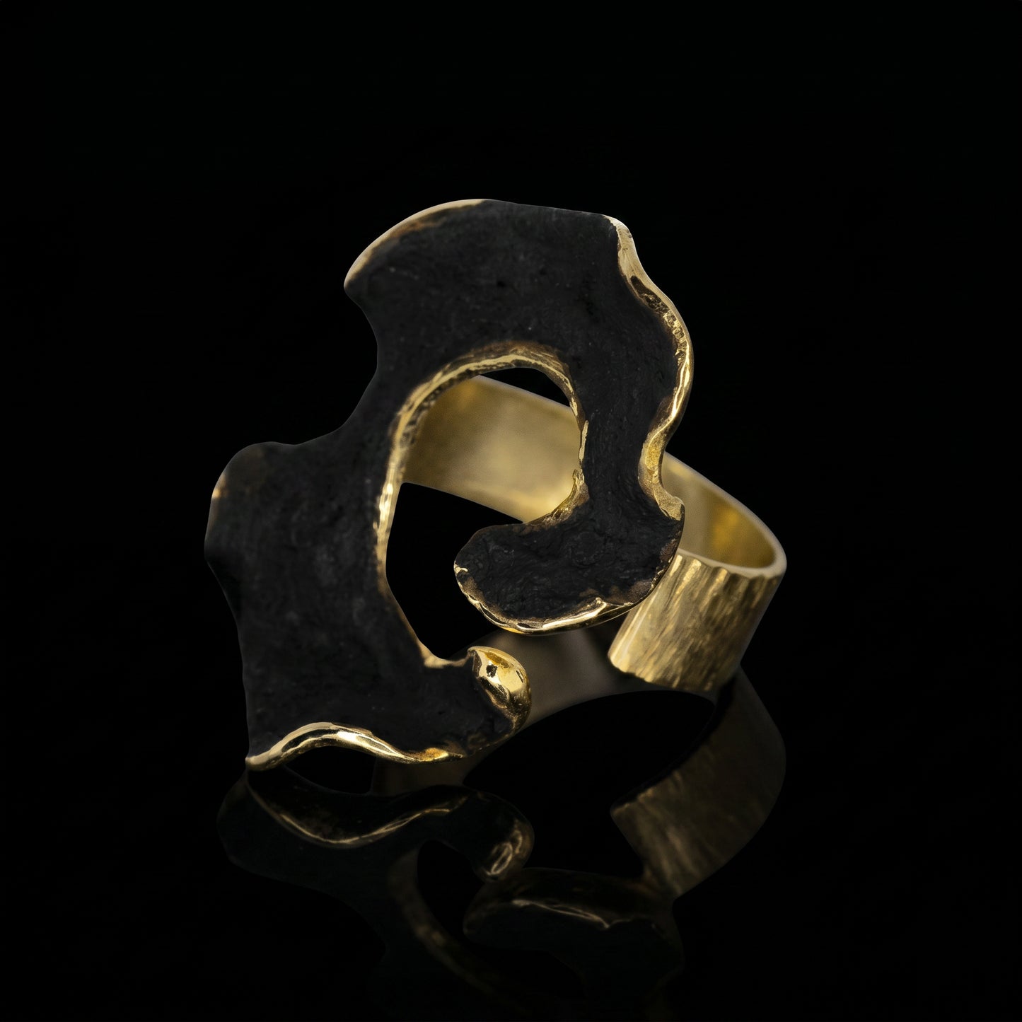 Dark blue and gold openwork ring with a wide sculpted band and cutout.