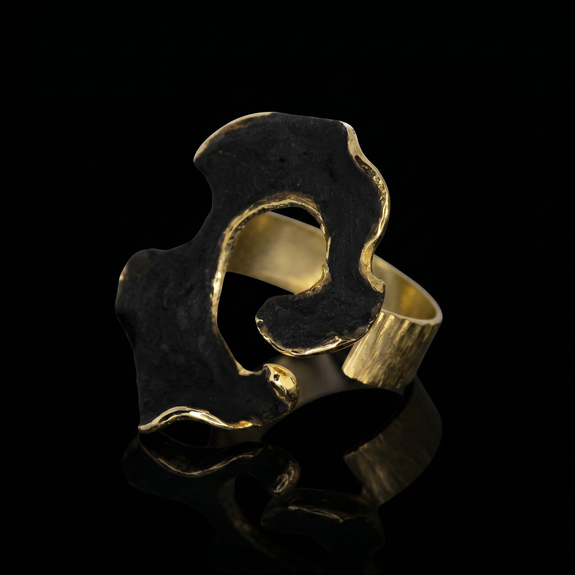 Dark blue and gold openwork ring with a wide sculpted band and cutout.