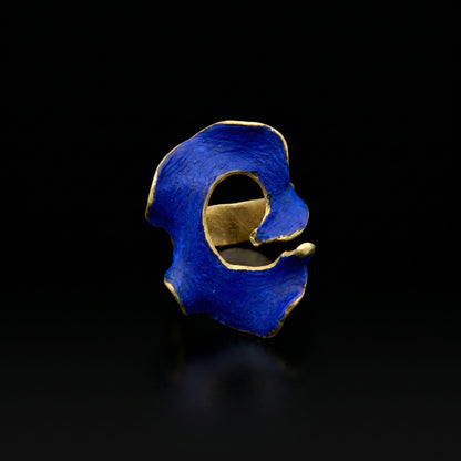 Blue statement ring with irregular openwork design and gold-tone band.