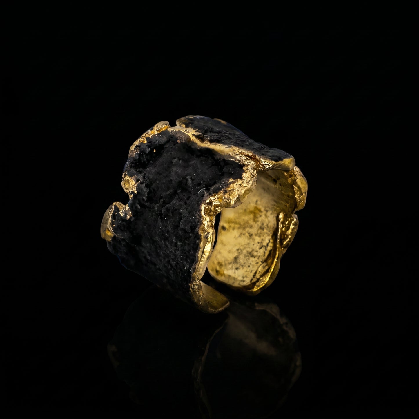 Gold-tone ring with dark stone and rough golden border