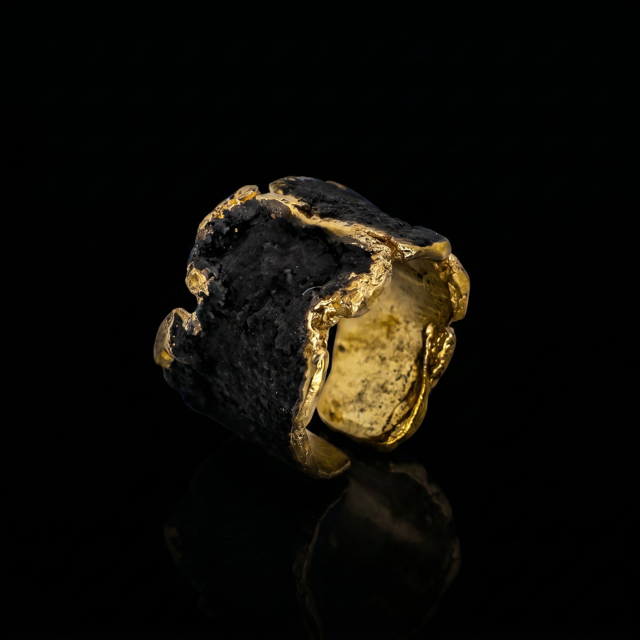 Gold-tone ring with dark stone and rough golden border