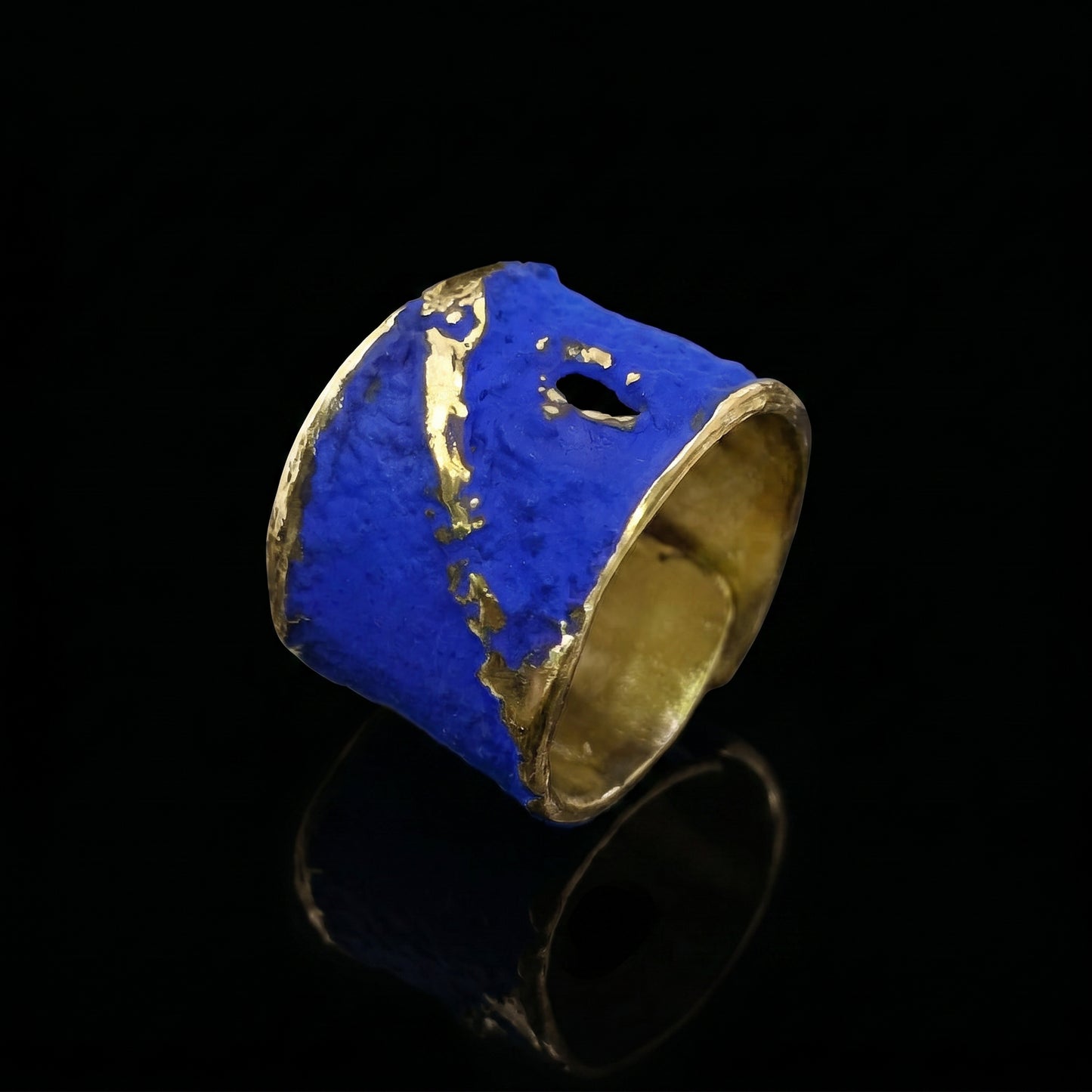 Blue enamel ring with gold-toned accents and sculpted, rounded top band