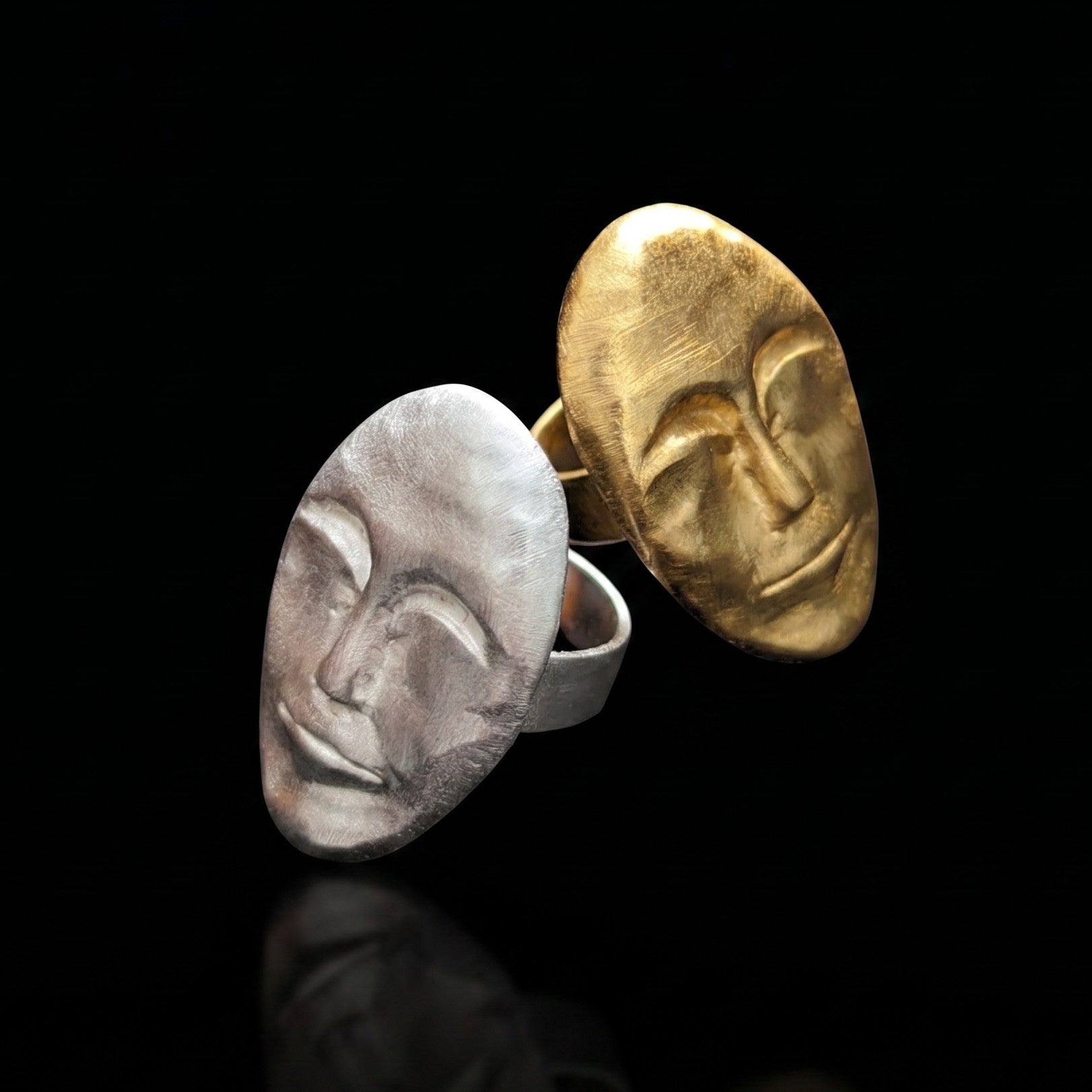 Pair of oval face rings, gold and silver, with textured sculpted profiles