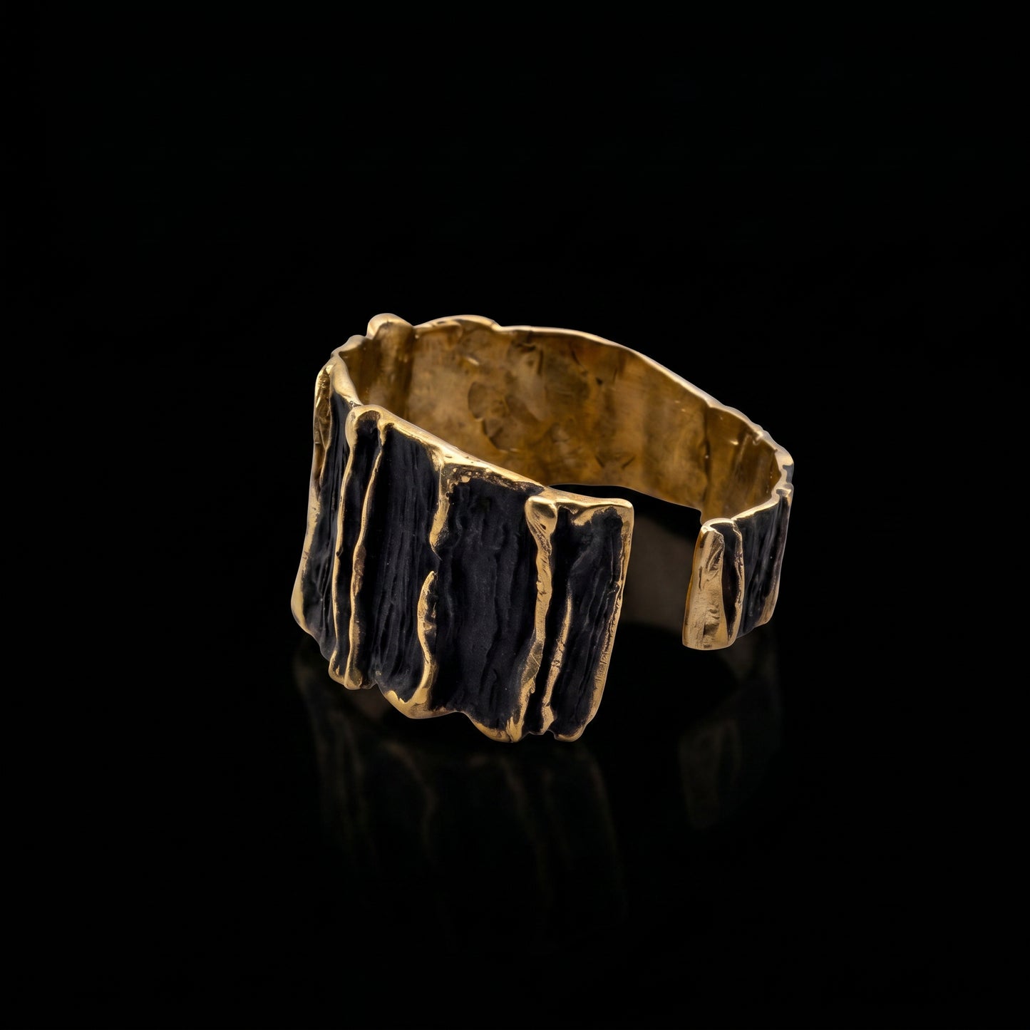 Wide sculpted cuff bracelet with gold-tone outer sides and dark ridged front