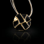 Gold-tone and black enamel concept necklace with oval pendant on thin chain