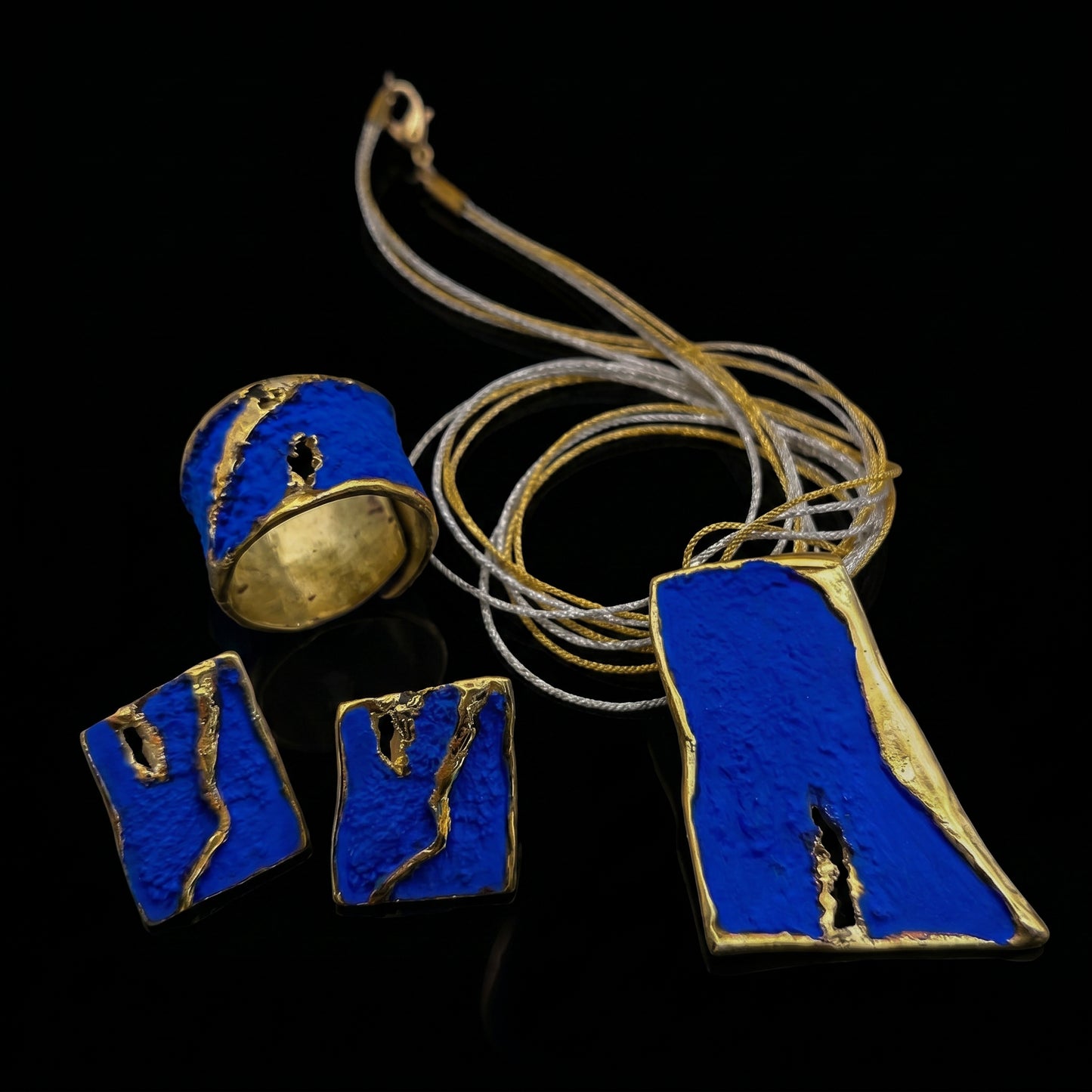 Blue enamel ring with gold-toned accents and black-inlaid detail, rounded band